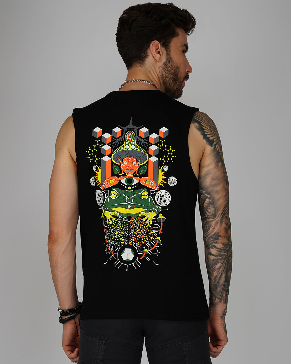 A man wearing a black sleeveless tank top with a colorful geometric pattern that glows in the dark.