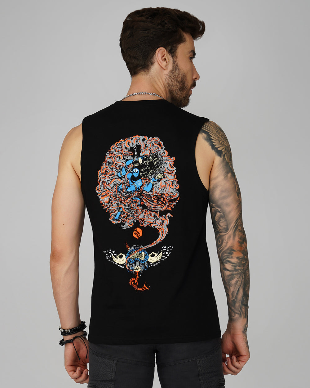 A man wearing a black tank top with a psychedelic art print of Shiva on the back, featuring a round neck and cut sleeves.