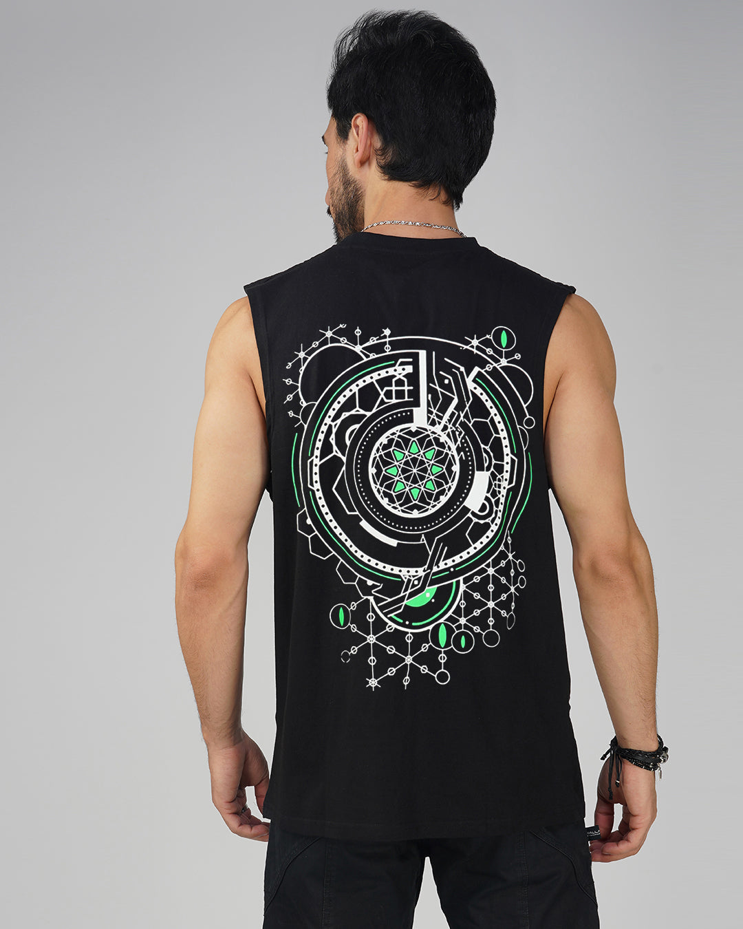 Man wearing a black sleeveless shirt with a geometric design on the back against a gray background