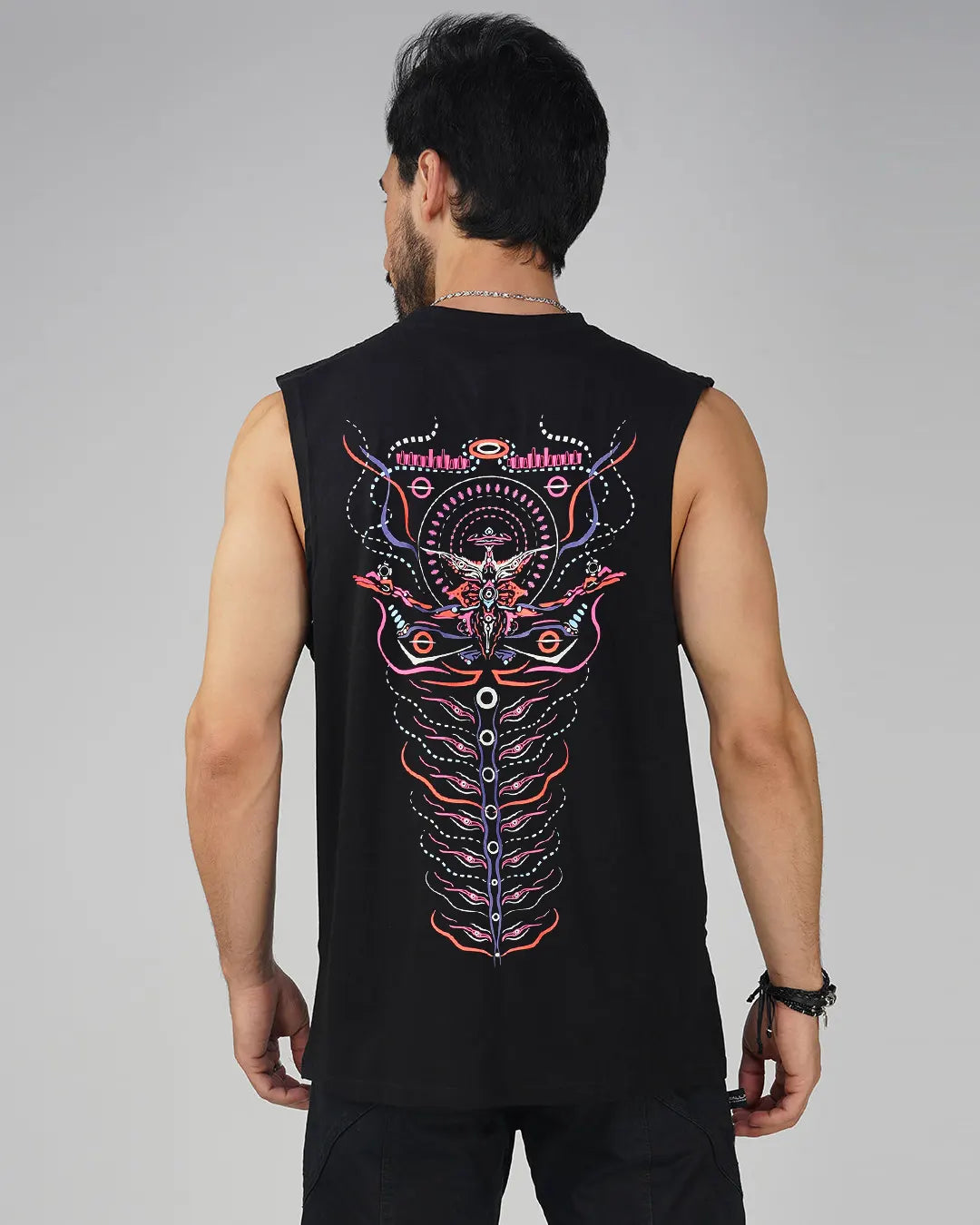 Man wearing a black sleeveless shirt with colorful back design on a gray background