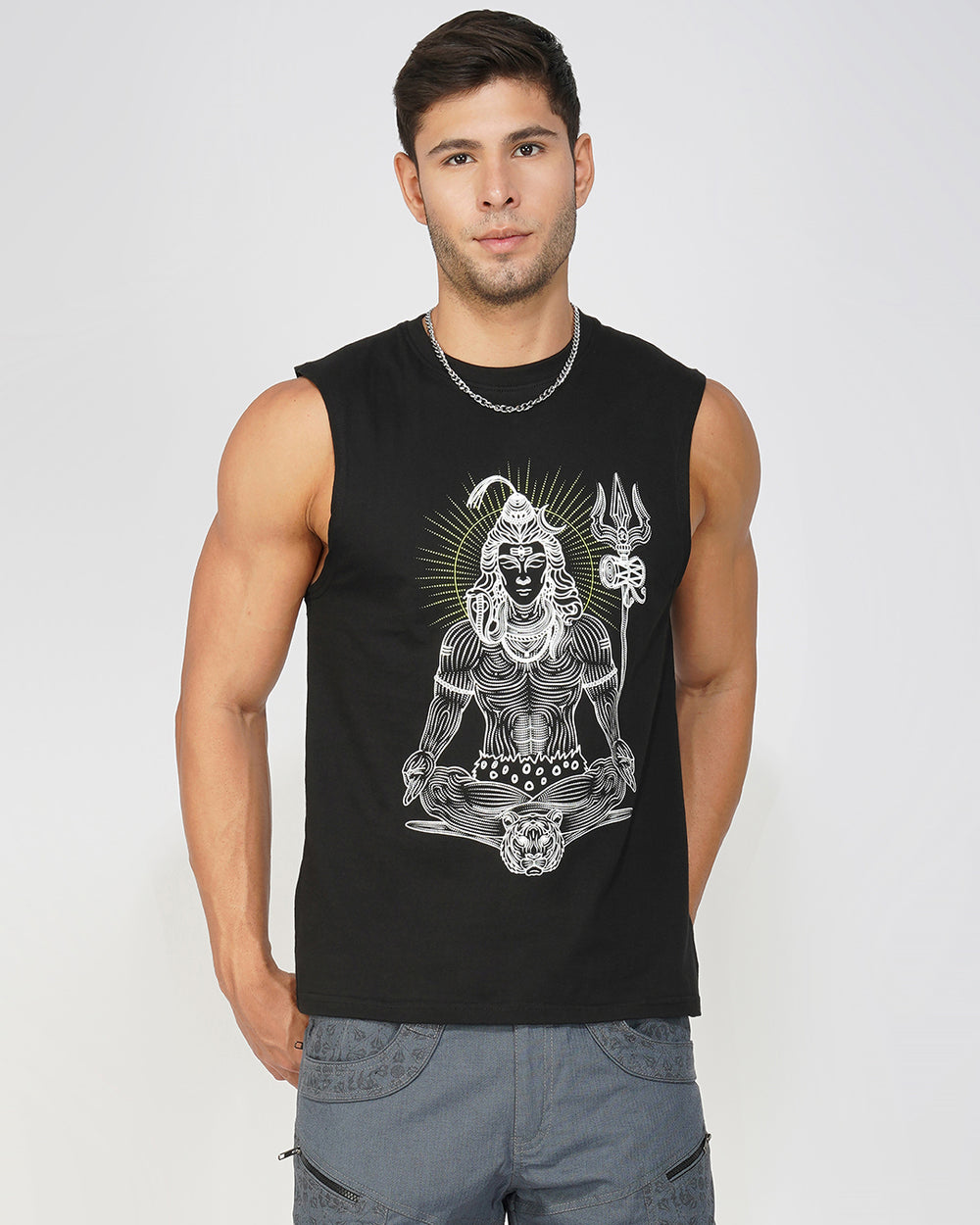 Man wearing a black sleeveless shirt with a graphic design on a plain background