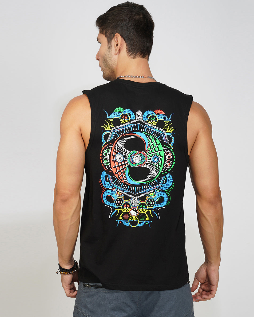 Man wearing a black sleeveless shirt with colorful abstract design on the back against a plain background
