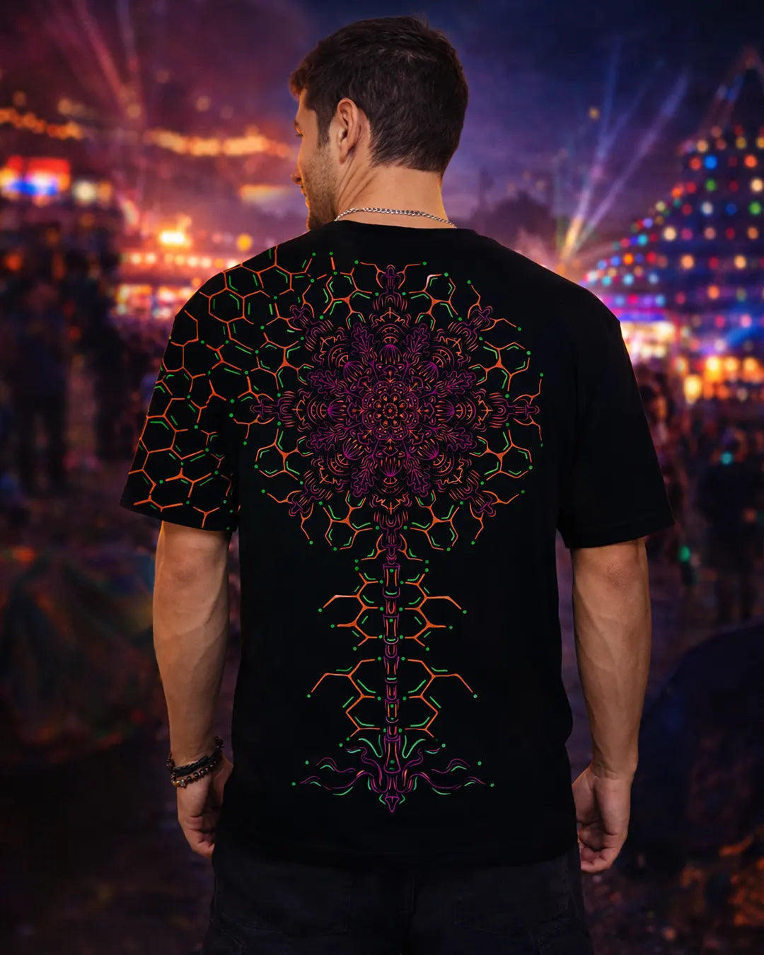 Person wearing a black t-shirt with a colorful geometric design at a concert.