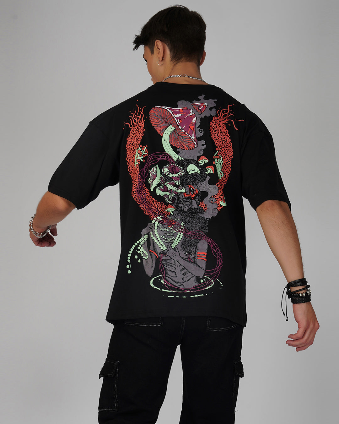 A person viewed from the back wearing a black oversized t-shirt with a psychedelic print.