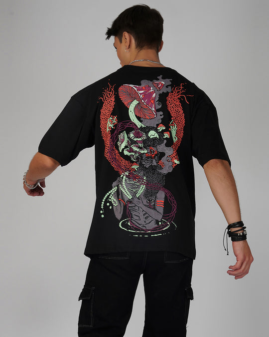 A person viewed from the back wearing a black oversized t-shirt with a psychedelic print.