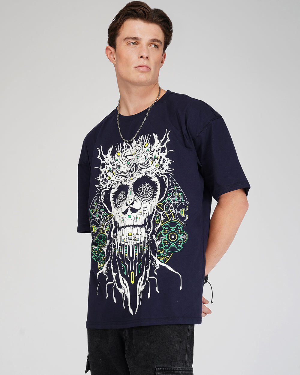 A person wearing an oversized navy blue t-shirt with a UV light reactive and glow-in-dark skull print.
