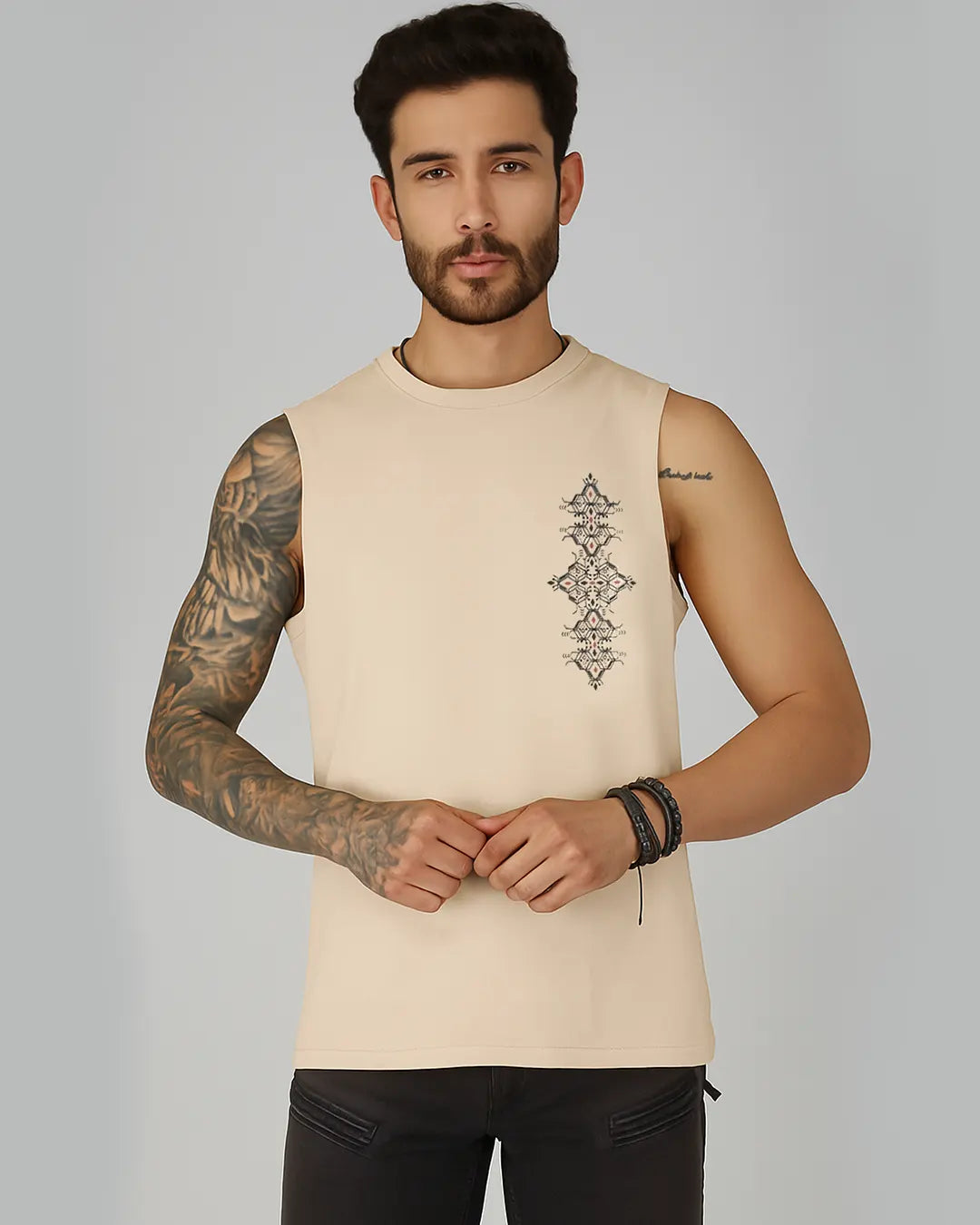 Man wearing a beige sleeveless shirt with a geometric design on a gray background
