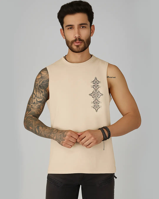 Man wearing a beige sleeveless shirt with a geometric design on a gray background