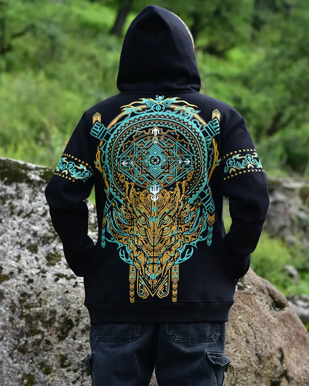 Person wearing a black 3d puff printed hoodie with a colorful geometric design on the back, standing outdoors.