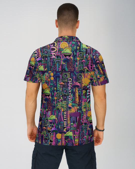 Man wearing a colorful patterned shirt on a plain background