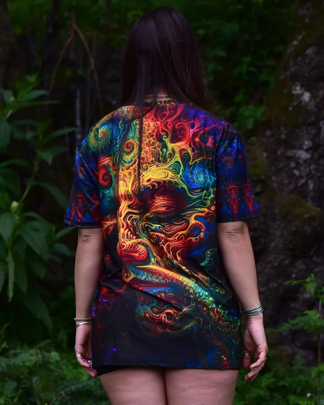 Person wearing a colorful tie-dye shirt with a dragon design outdoors.