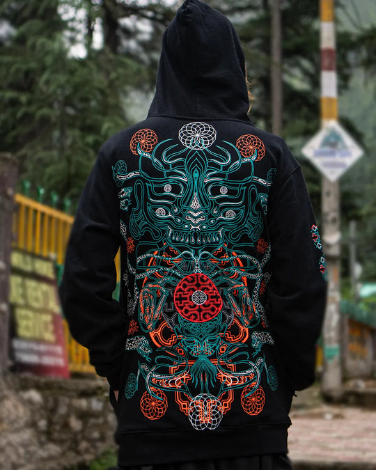 Person wearing a black hoodie with a colorful dragon design on the back, standing outdoors.