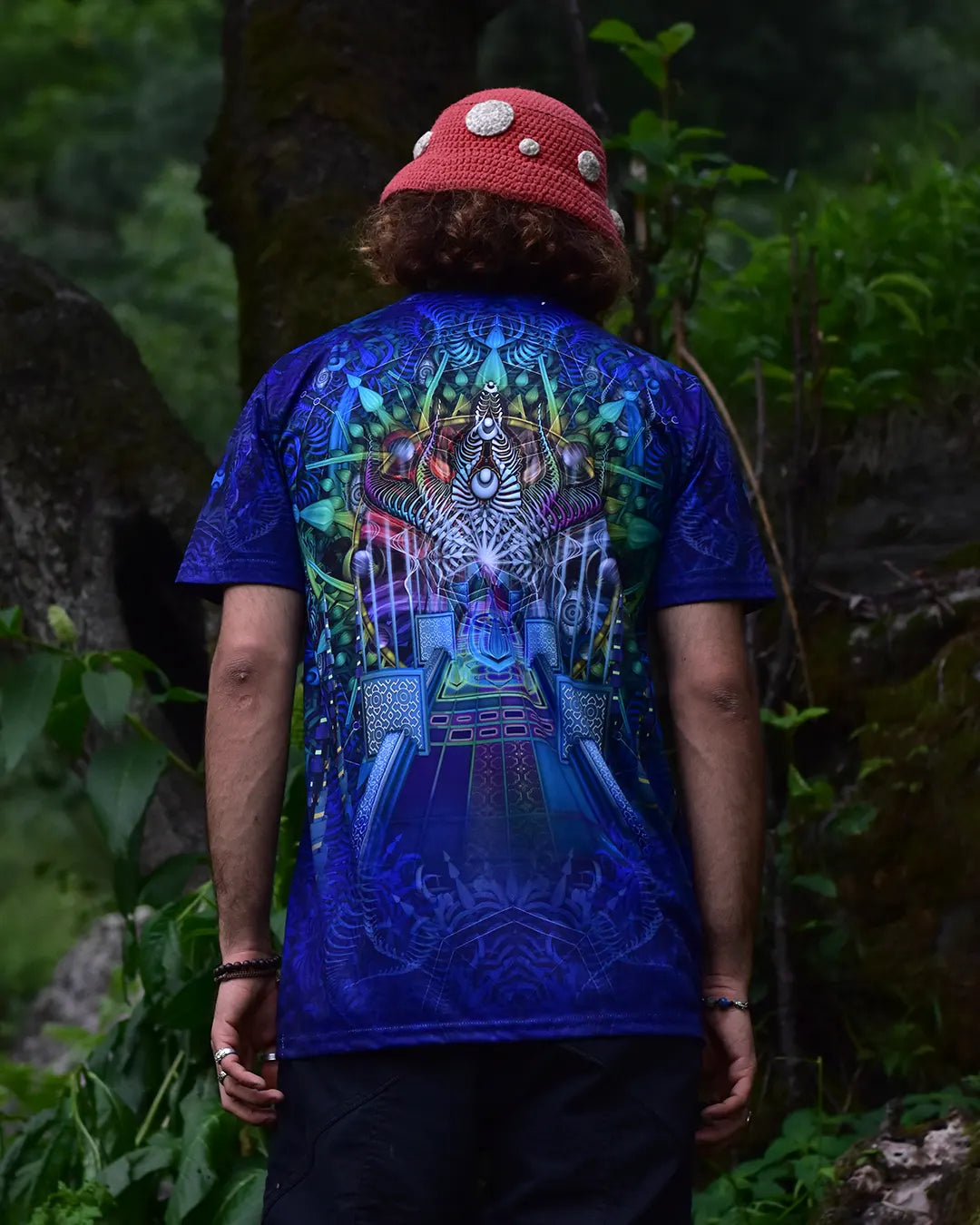 Person wearing a blue t-shirt with a colorful design outdoors