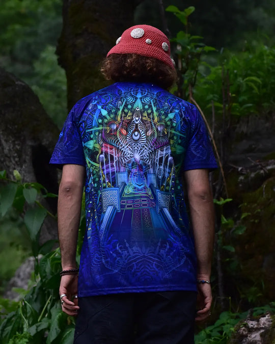 Person wearing a blue t-shirt with a colorful design outdoors