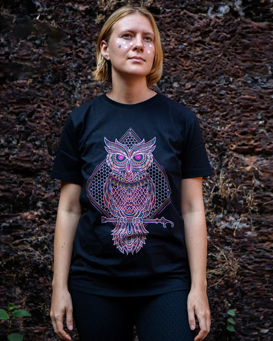 Woman wearing a black t-shirt with a purple owl design against a natural background