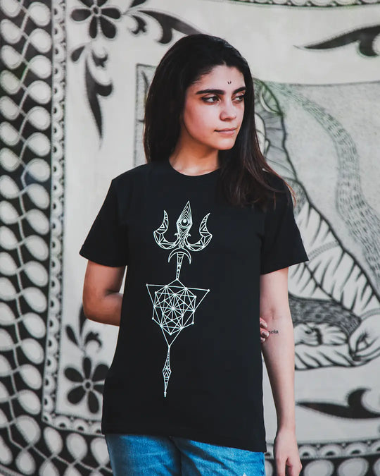 Person wearing a black t-shirt with a geometric trident design in front of a patterned wall.
