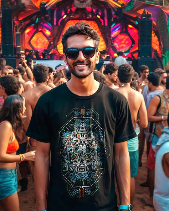 Man wearing a black t-shirt with a colorful design in a lively crowd setting