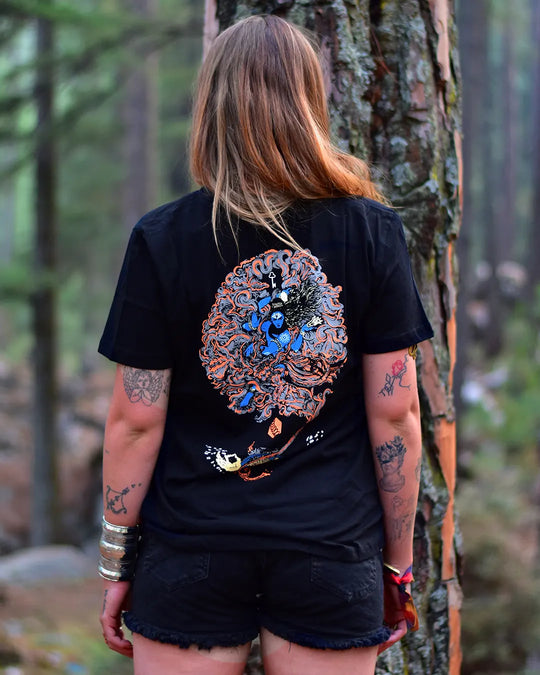 Person wearing a black t-shirt with a god shiva colorful design in a forest