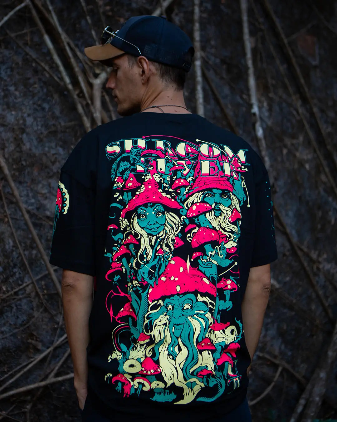 Person wearing a black t-shirt with colorful graphic design against a dark background