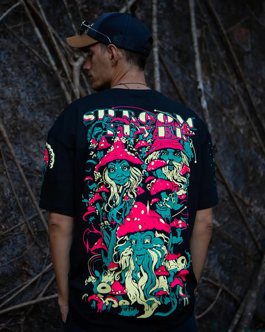 Person wearing a black t-shirt with colorful graphic design against a dark background