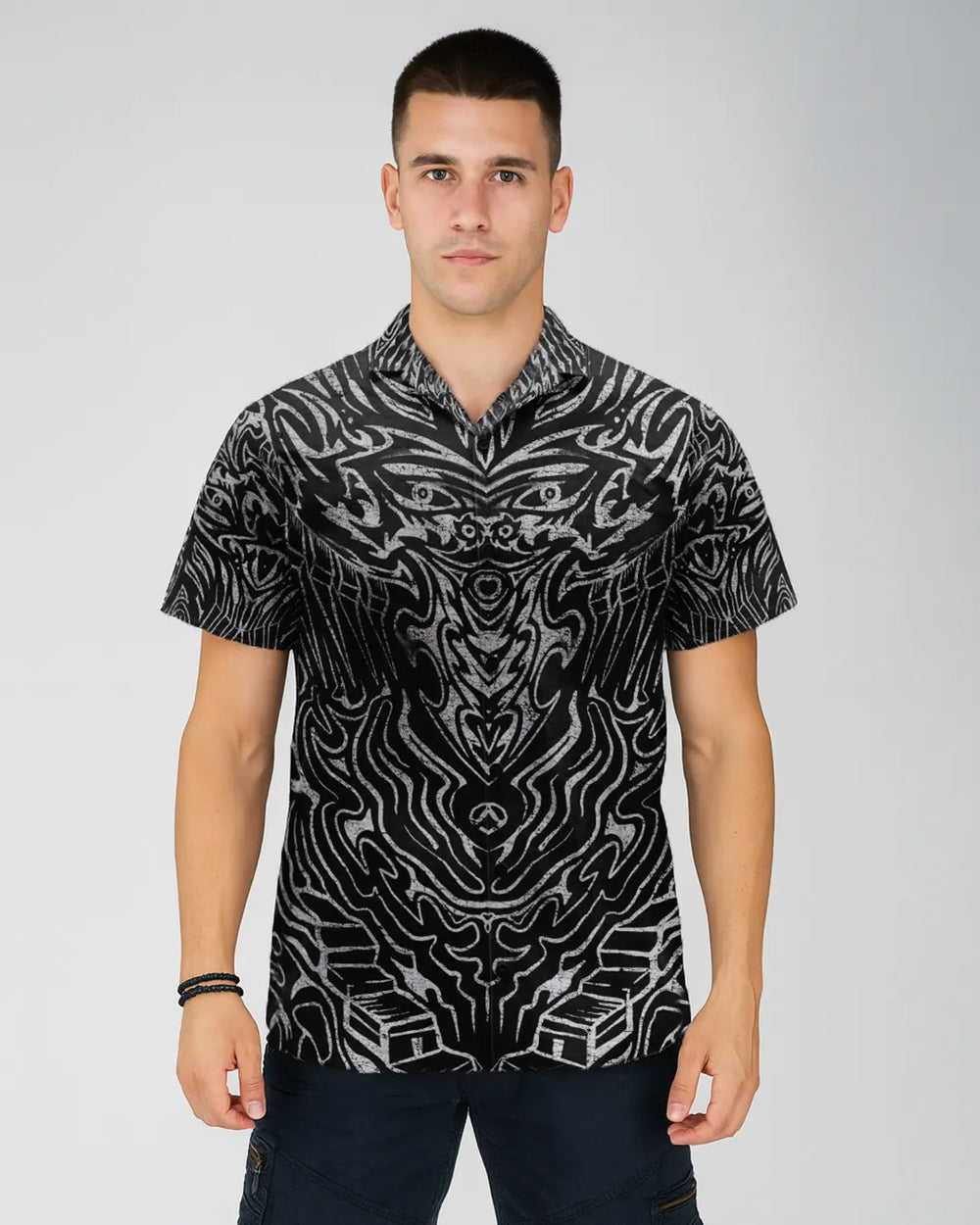 Man wearing a black and white patterned shirt on a gray background