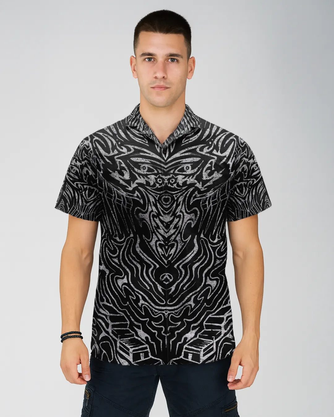 Man wearing a black and white patterned shirt on a gray background