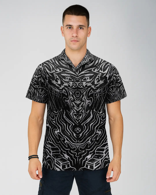 Man wearing a black and white patterned shirt on a gray background