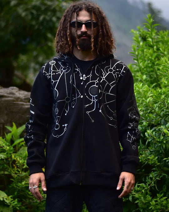 Person wearing a black hoodie with white designs outdoors