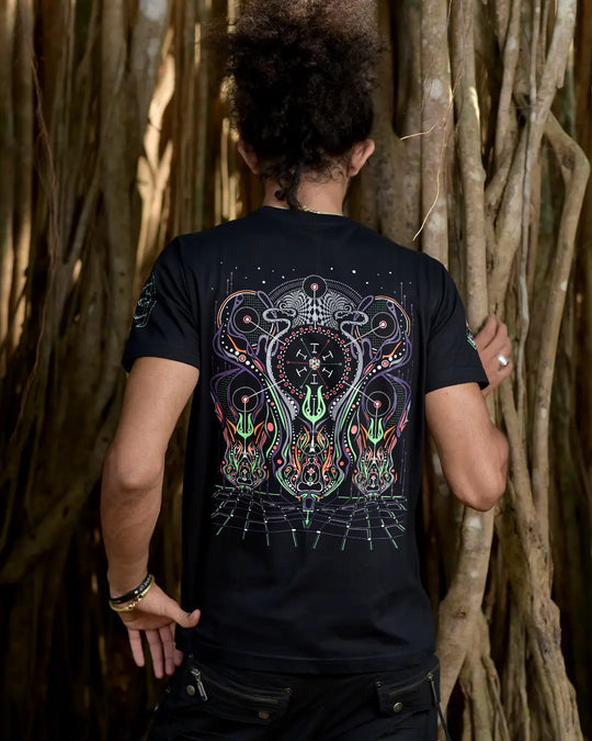 Person wearing a black t-shirt with a colorful design, standing against a natural background.