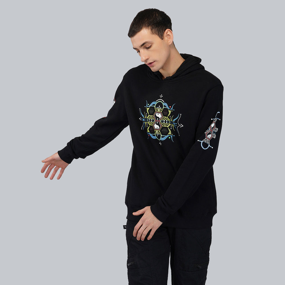 A male model wearing a black cotton hoodie with a UV reactive and glow in the dark effect on the sleeves.
